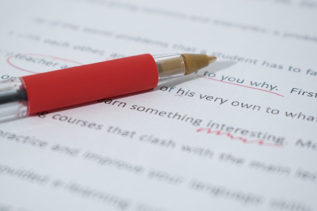 red pen marking proofreading corrections on page