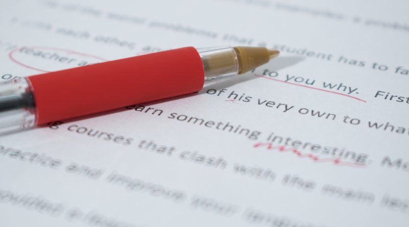 red pen marking proofreading corrections on page