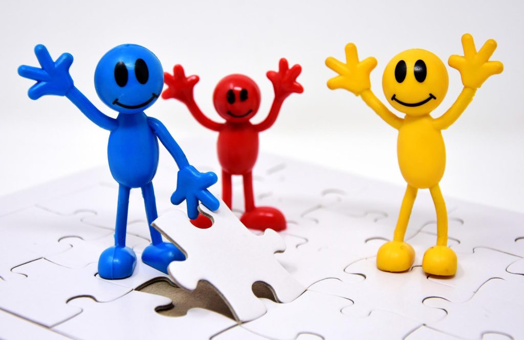 team of 3 smileys finishing a puzzle