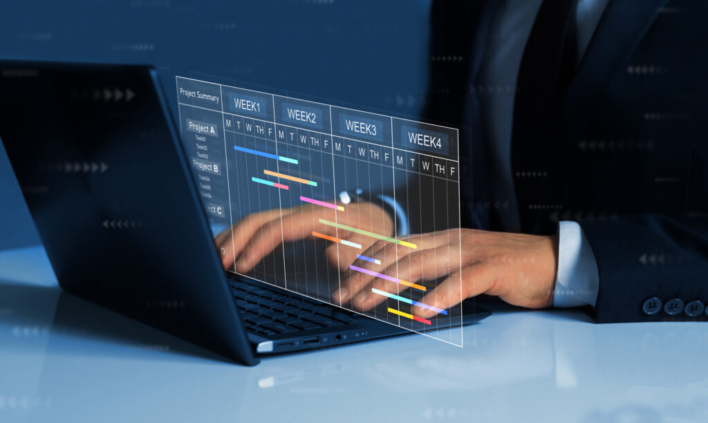 project manager updating tasks on laptop
